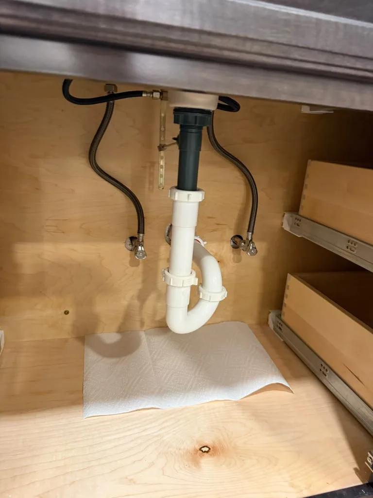 P-trap and drain assembly installed under a bathroom vanity sink