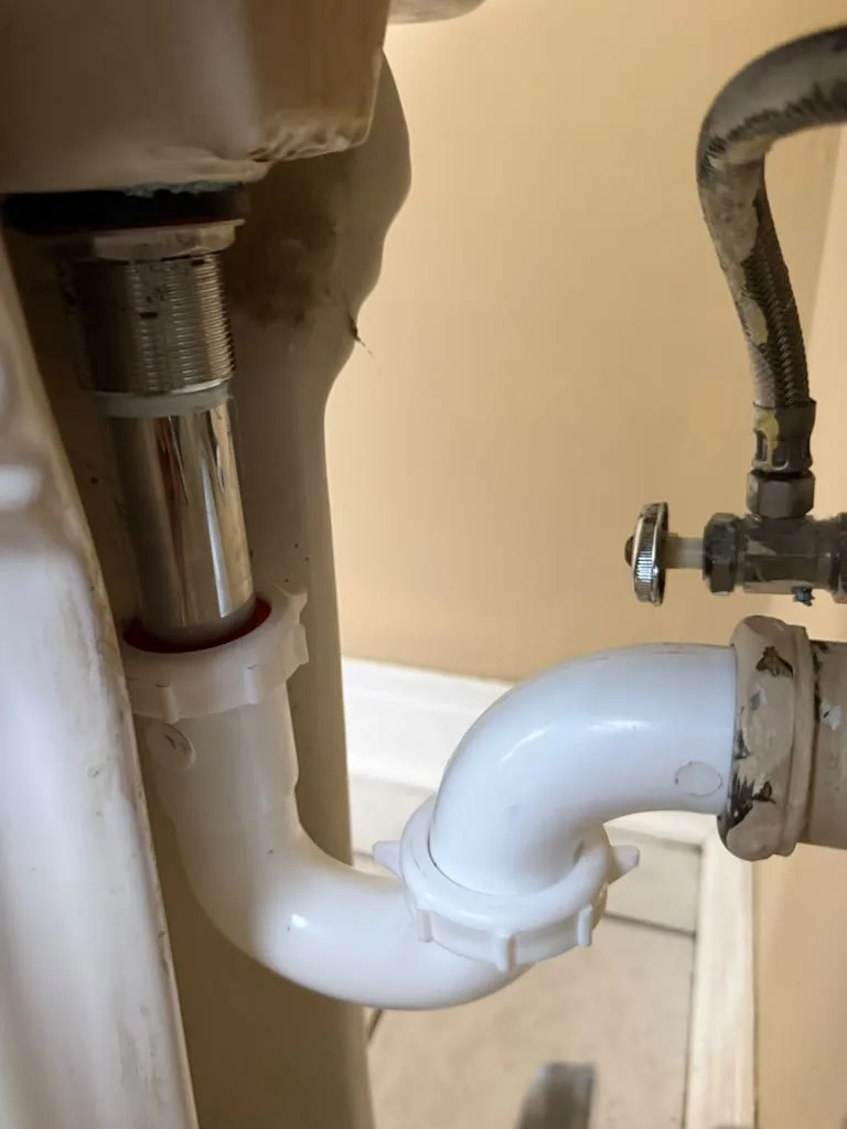 New P-trap and drain pipe installed under a bathroom sink
